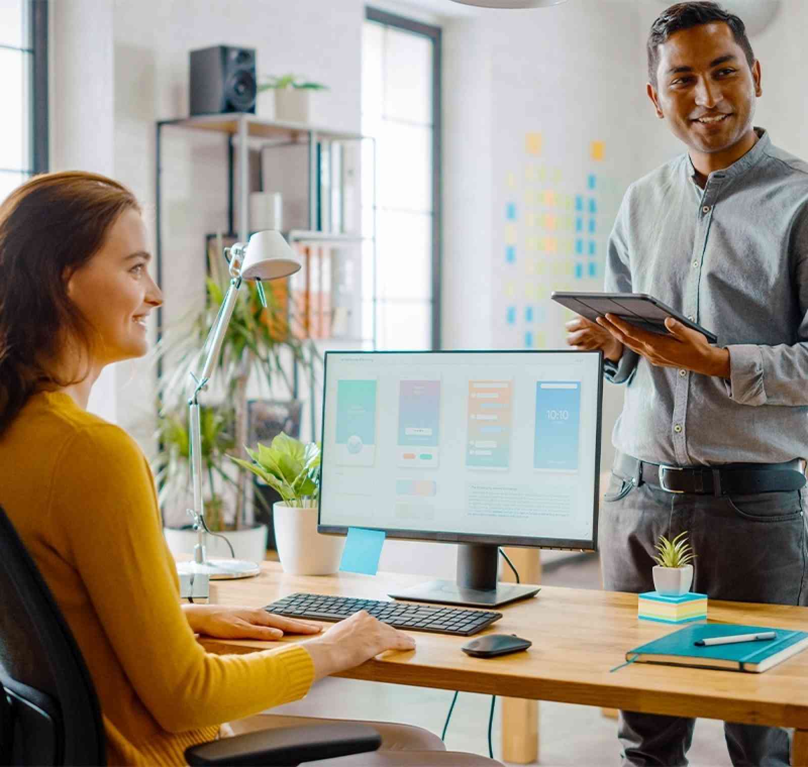 A Microsoft Office Specialist works at a modern desk using a computer to create and format documents, spreadsheets, and presentations, demonstrating advanced Microsoft Office skills and professional certification.