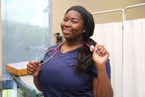 Smiling nurse with stethoscope in clinic